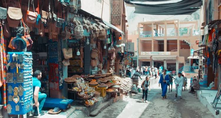 Calle del mercado con gente y productos tradicionales.