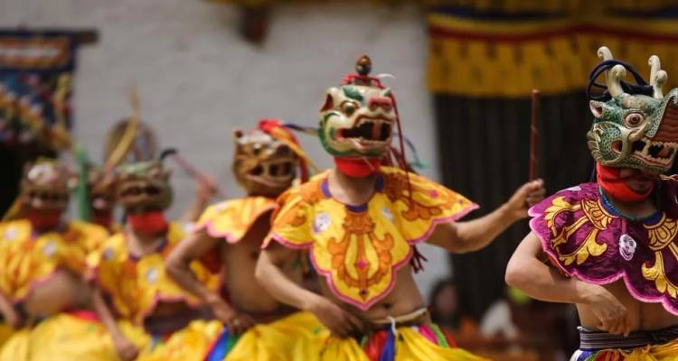 Bhutanische maskierte Tänzer wirbeln in leuchtenden Kostümen während des Kloster-Tshechu-Festivals herum.