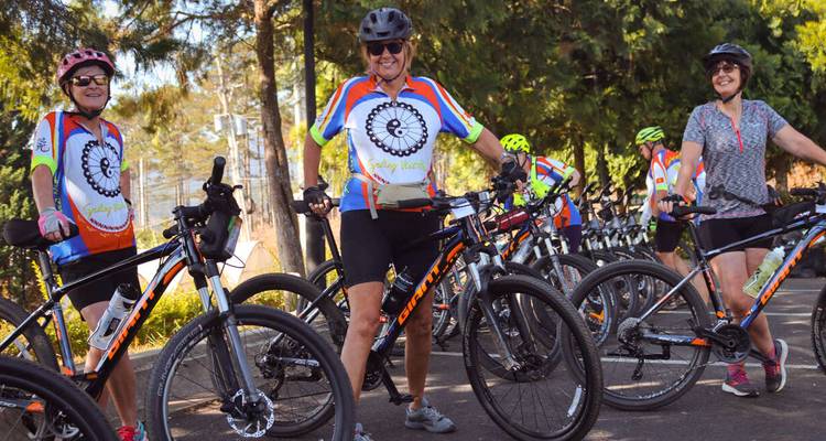 Cyclists gathered with bikes, wearing matching jerseys.