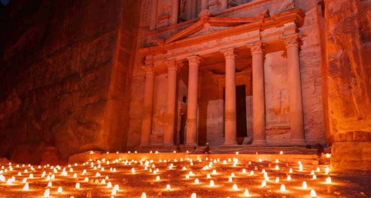 The Treasury of Petra illuminated by hundreds of small candles at night within the rose-red canyon.