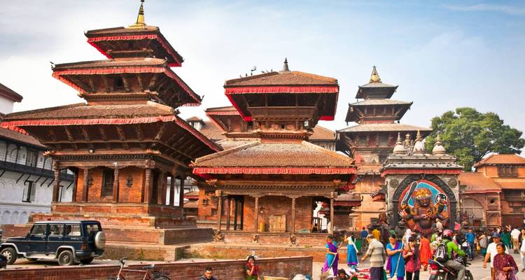 Traditional architecture in Kathmandu with people walking nearby.