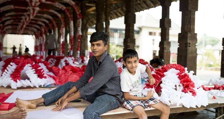 Two people sitting in a decorated hall with red and white streamers.