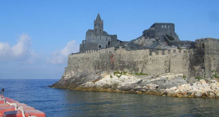 Historische Steinfestung am Meer mit felsigem Vordergrund.