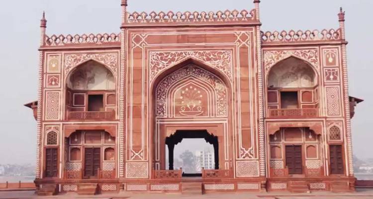 Ein prächtiges Tor aus rotem Sandstein mit kunstvollen Schnitzereien und Intarsienarbeit.