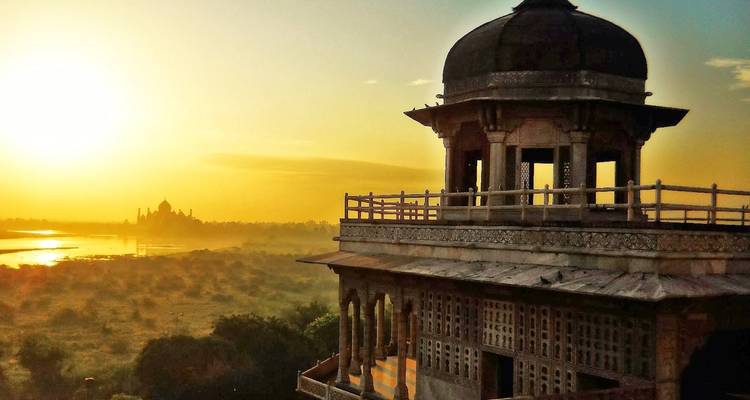 Schilderachtig uitzicht met fort en de Taj Mahal in de verte bij zonsopgang.