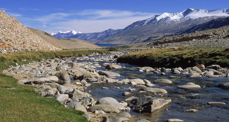 River flowing through a mountainous landscape with snow-capped peaks.