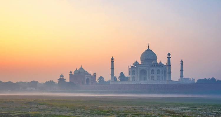 Das Taj Mahal bei Sonnenaufgang mit Nebel im Vordergrund.
