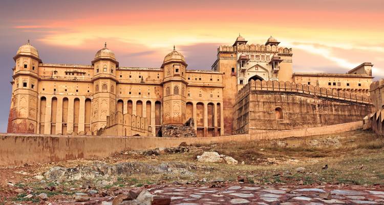 Un fort historique impressionnant avec des tours et des créneaux au coucher du soleil.