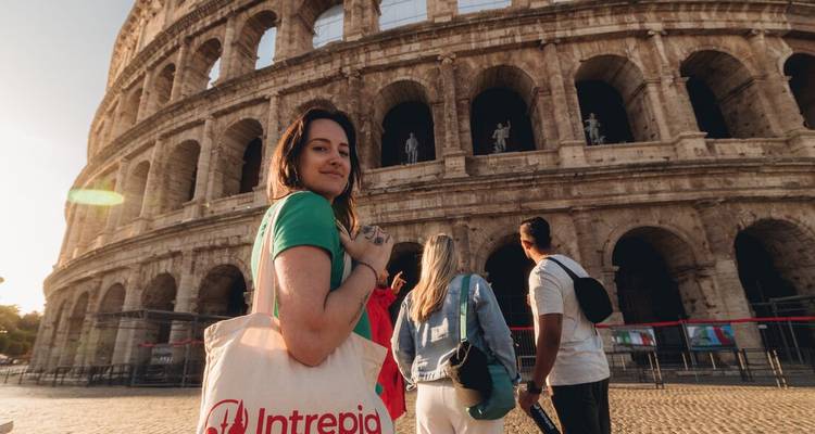 Un voyageur avec un sac fourre-tout Intrepid pose devant le Colisée de Rome alors que la lumière de l'après-midi frappe les arches de pierre.