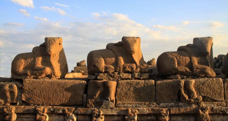 Ancient stone sculptures against a backdrop of blue sky.