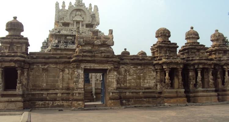 Intricate temple architecture with sculptures and a cloudy sky.