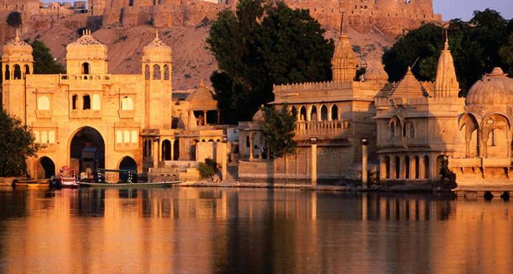 Gouden gebouwen bij een meer bij zonsondergang.