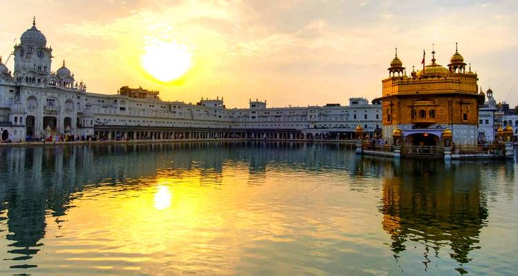 Templo Dorado en Amritsar con un brillante reflejo del sol en el agua.
