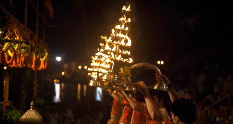 Religieuze ceremonie met mensen die vuurlampen vasthouden.