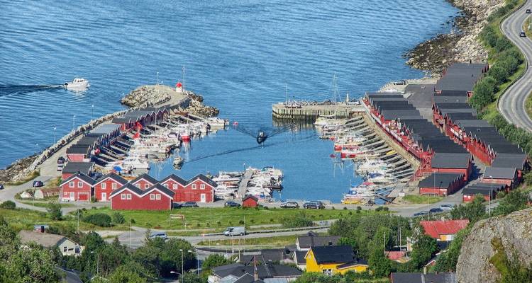Port avec des bâtiments rouges et de nombreux bateaux amarrés.