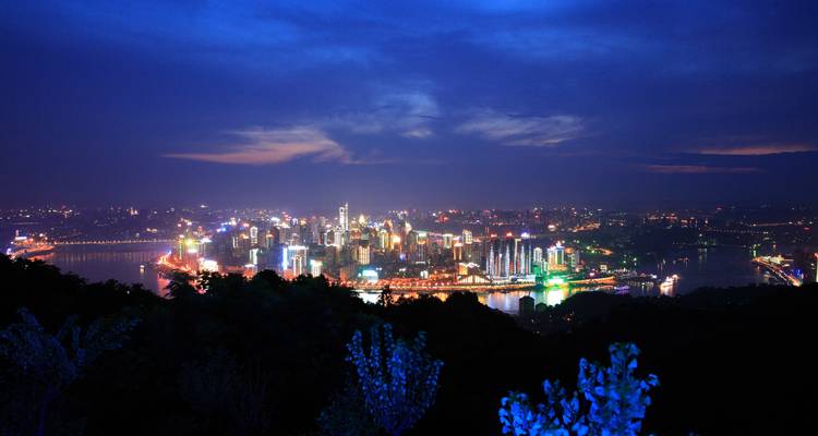 Aerial view of a brightly lit cityscape at night.