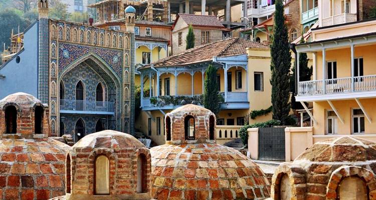 Historic cityscape with thermal bath domes and colorful buildings.