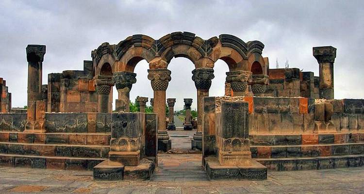 Ruinas de antiguos arcos de piedra rodeadas por un paisaje rocoso.