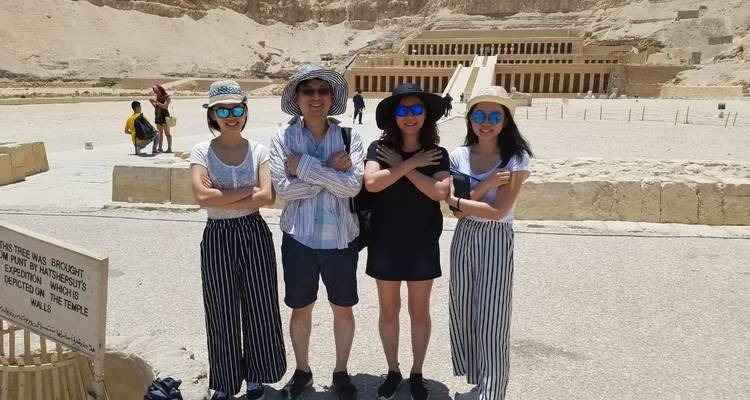 Grupo de turistas posando frente a un templo egipcio antiguo.