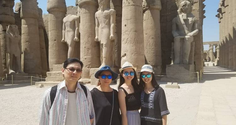Groupe de touristes posant devant de grandes statues