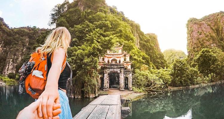 Une femme tenant la main de quelqu'un, le menant vers un temple.