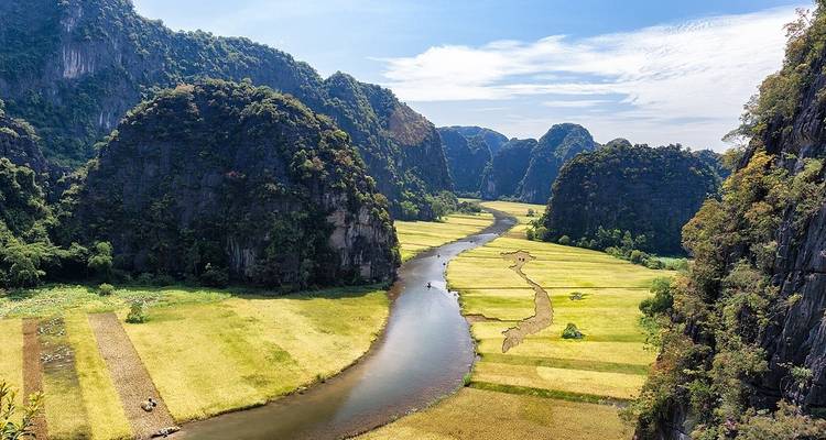 Vue panoramique d'une rivière serpentant à travers des montagnes verdoyantes.