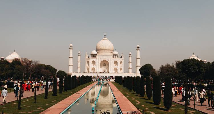 Klassische Frontalansicht des Taj Mahal mit seinem Spiegelungsbecken und Besuchermassen.
