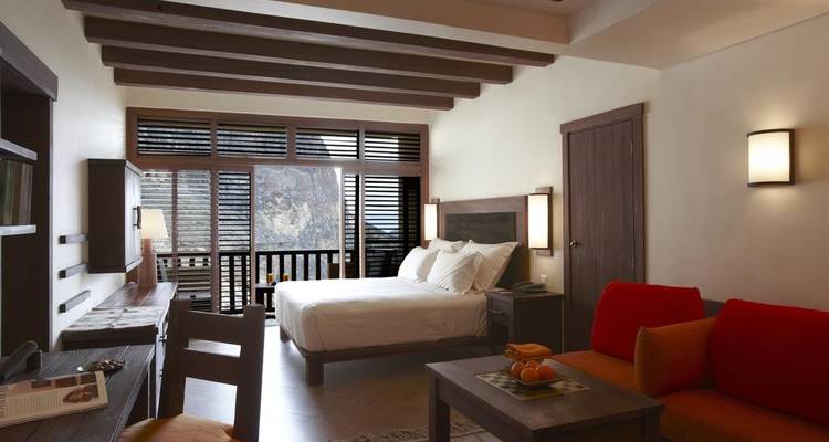 Intérieur d'une chambre d'hôtel moderne avec un lit et des sièges confortables.