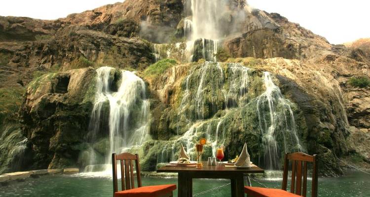 Un aménagement de salle à manger près d'une cascade, offrant une expérience culinaire unique.