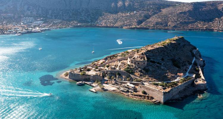 Espectacular vista aérea de la isla de Spinalonga rodeada de aguas turquesas vibrantes.