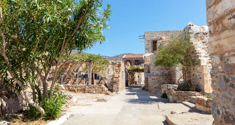 Callejones de piedra iluminados por el sol y muros en ruinas de la antigua colonia de leprosos en Spinalonga.