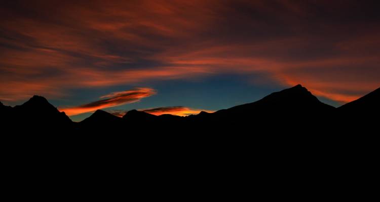 Silhouet van bergen tijdens zonsondergang.