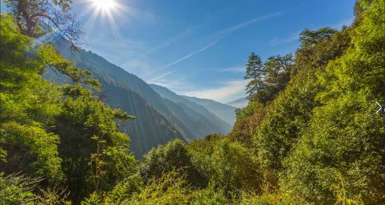 Schilderachtig uitzicht op een bergachtige vallei met zonlicht dat erdoorheen schijnt.