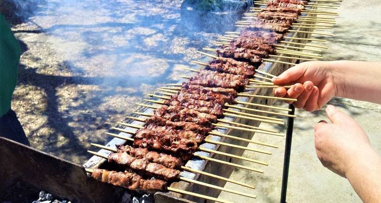 Brochettes de viande grillées à la main sur un barbecue.