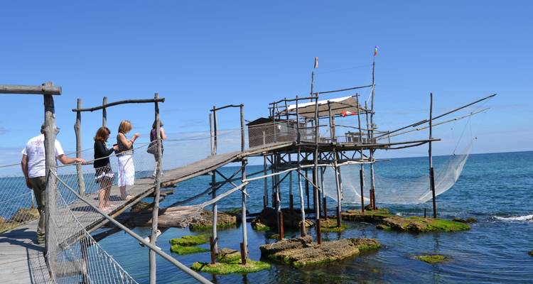 Des gens regardent une plateforme de pêche.