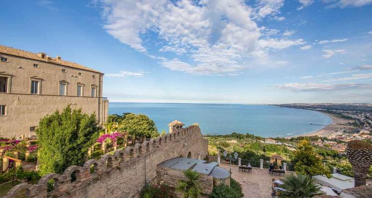 Panoramic view of a coast and city from a high vantage point with a blue sea.
