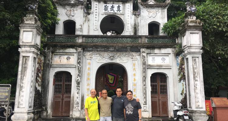 Vier Personen stehen vor einem historischen Tor.