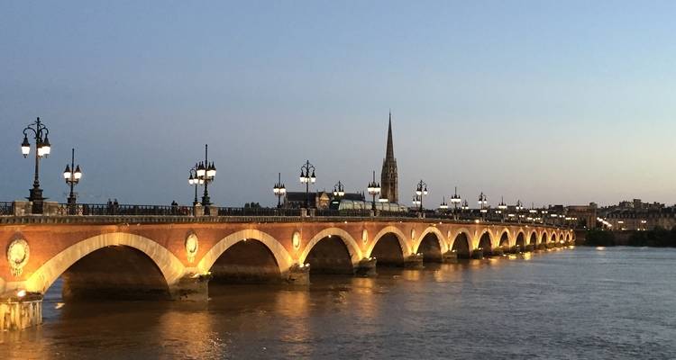 Un puente histórico iluminado al anochecer.