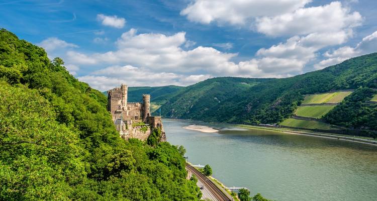 Château sur une colline surplombant une rivière et une vallée.