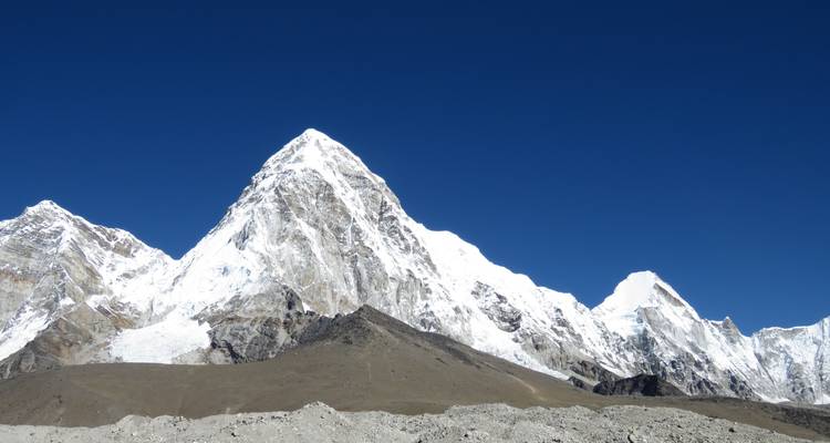 Picos afilados de montañas cubiertas de nieve bajo un cielo azul despejado.