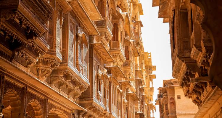 Narrow golden sandstone alley lined with intricately carved havelis in Jaisalmer's old town.