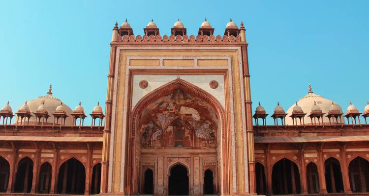 Puerta histórica con tallados detallados bajo un cielo azul.