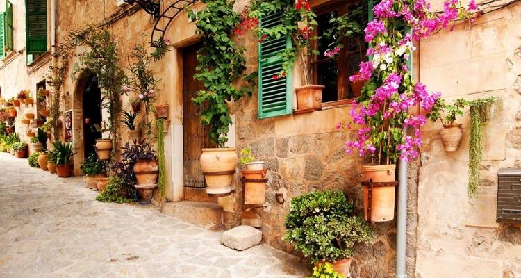 Una calle encantadora con edificios de piedra y flores vibrantes.