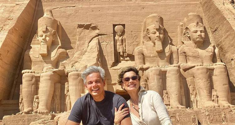 Deux personnes sont assises devant les temples d'Abou Simbel.