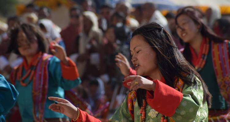 Personas con vestimenta tradicional butanesa realizando una danza.