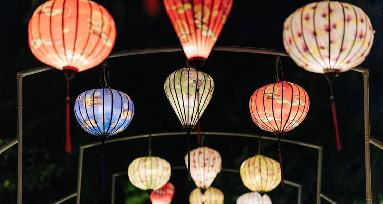 Colorful paper lanterns glowing at night in neat rows during an Asian festival.