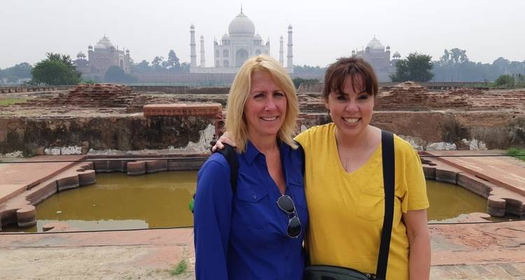 Dos mujeres posando con el Taj Mahal de fondo.