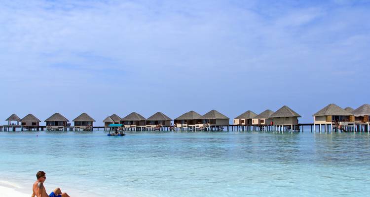 Overwater bungalows met helder blauw water.