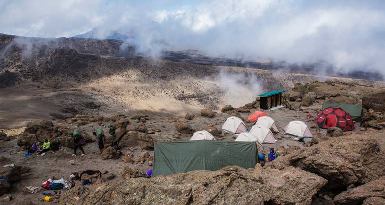 High camp on Kilimanjaro with clusters of tents perched above the clouds