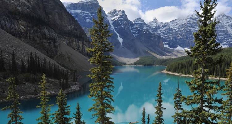 El Lago Moraine de color azul glacial enmarcado por el escarpado Valle de los Diez Picos bajo un brillante cielo de verano.